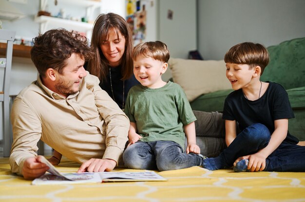 happy-family-with-two-little-sons-reading-story-indoors-parents-with-children-spending-time-together-and-lying-on-the-floor-at-home_155404-1375.png
