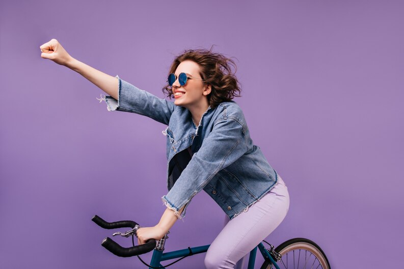 [fpdl.in]_confident-girl-in-denim-jacket-riding-on-bike-and-waving-hand-indoor-photo-of-inspired-young-lady-in-glasses-sitting-on-bicycle_197531-20552_medium.jpg